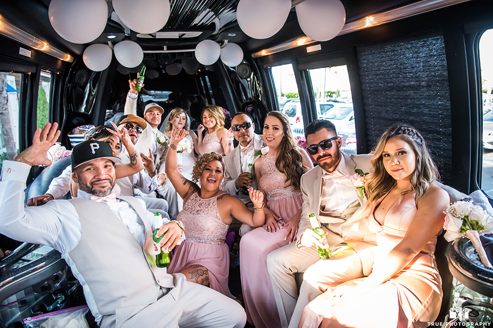 the bridal party poses in a limo