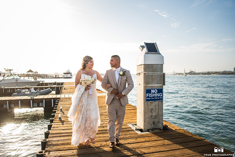 Wedding bride and groom walking on a boardwalk in San Diego 