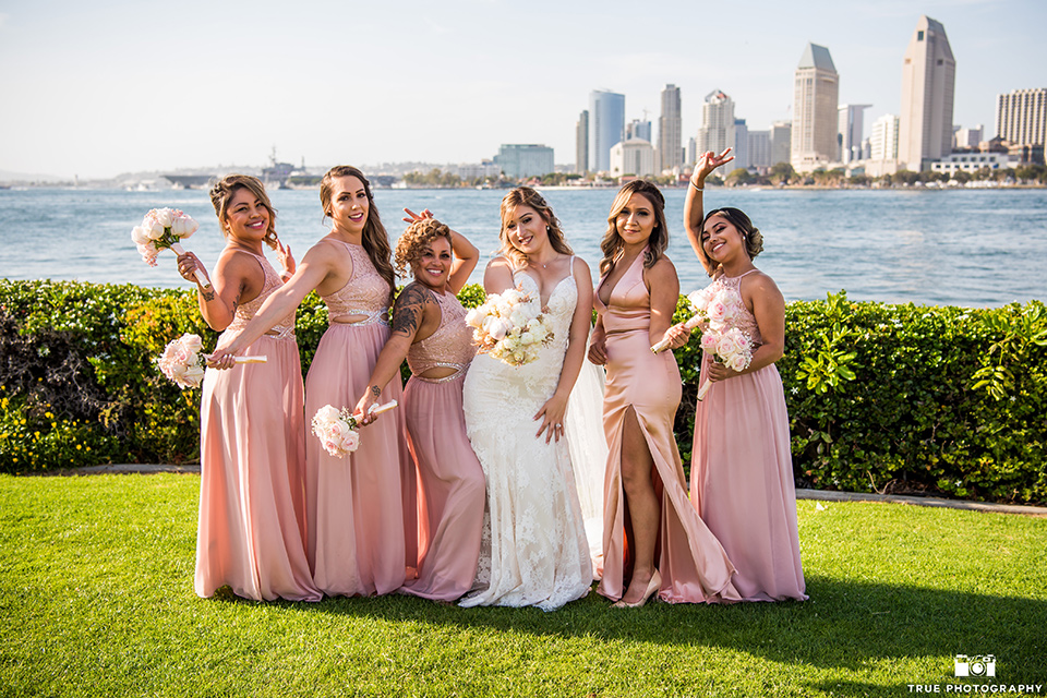 bride and bridesmaids pose in front of san diego skyline