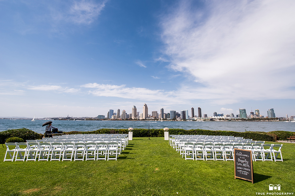 Fiesta Hall wedding ceremony space overlooking the bay with the city scenery in the background with white chairs for guests