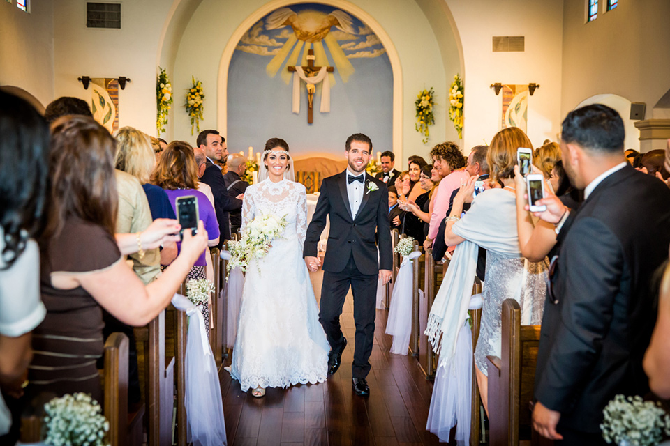 Admiral Kidd Club bride and groom after ceremony bride in a lace and tulle gown with a high neckline and sleeves groom in a traditional black tuxedo