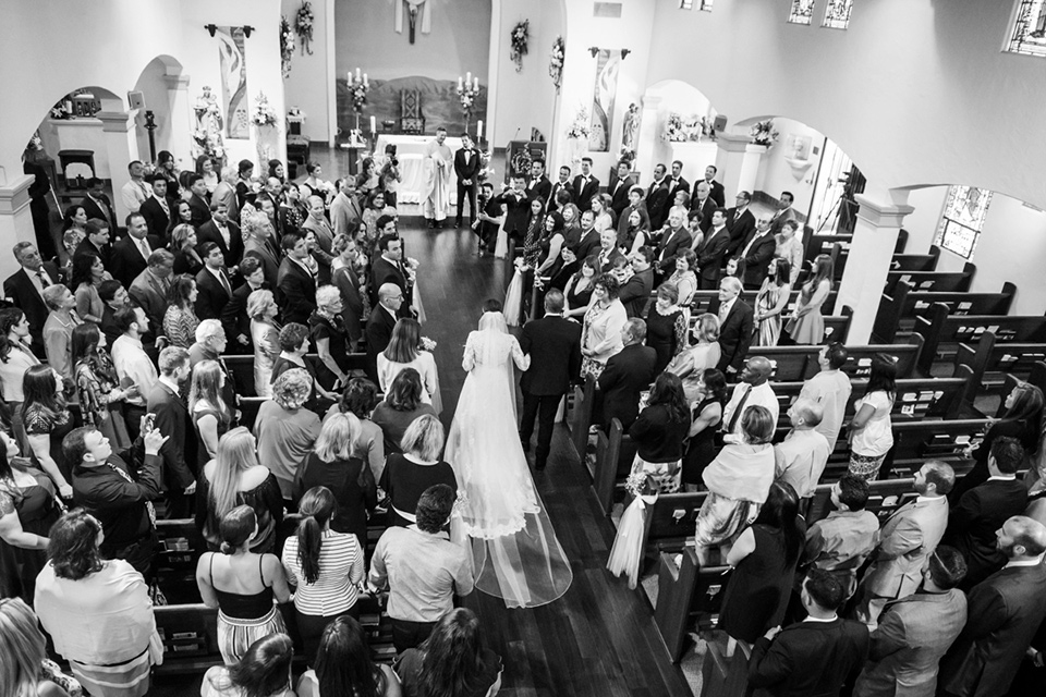 Admiral Kidd Club ceremony bride walking down the aisle bride in a lace and tulle gown with a high neckline and sleeves groom in a traditional black tuxedo