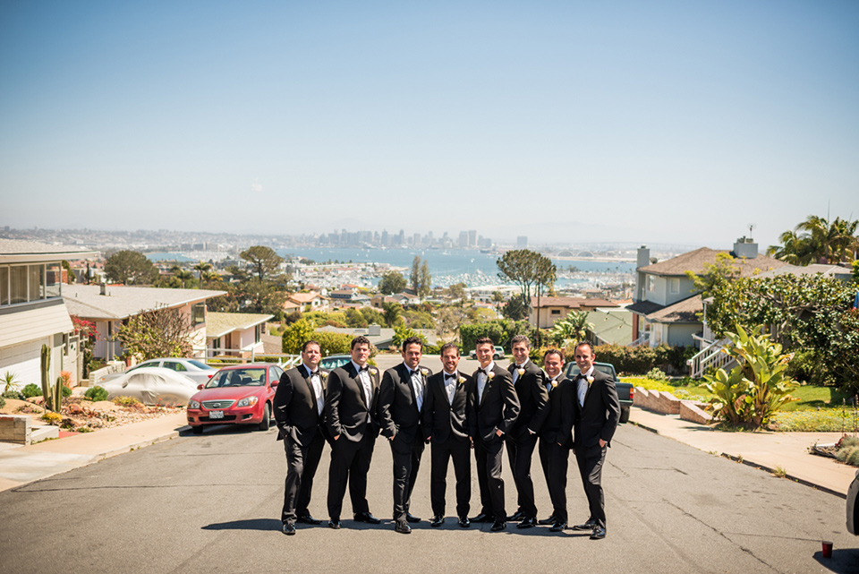 groomsmen  in  black  tuxedos  groom  in  a  traditional  black  tuxedo posing in front of San Diego skyline