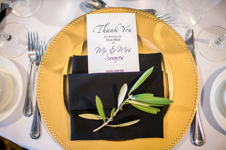 Admiral Kidd Club place setting with gold plates and black napkins