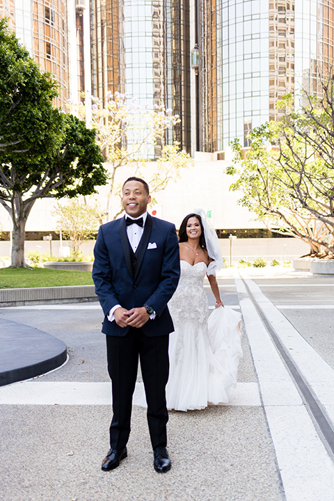 walt-disney-concert-hall-first-look-bride-in-a-mermaid-style-gown-with-a-elbow-length-veil-groom-in-a-navy-shawl-lapel-tuxedo