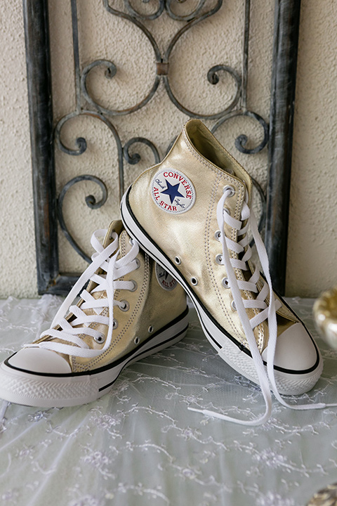 White converse shoes set up on white lace cloth to match wedding style