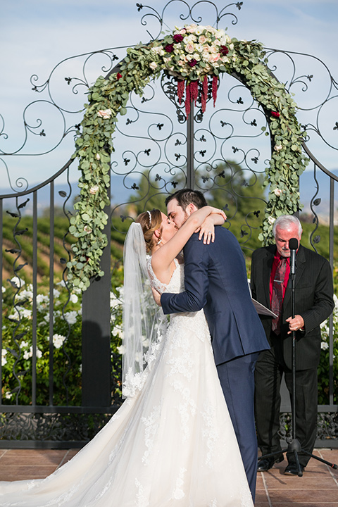 bride and groom share first kiss in front of altar at temecula vineyard wedding 