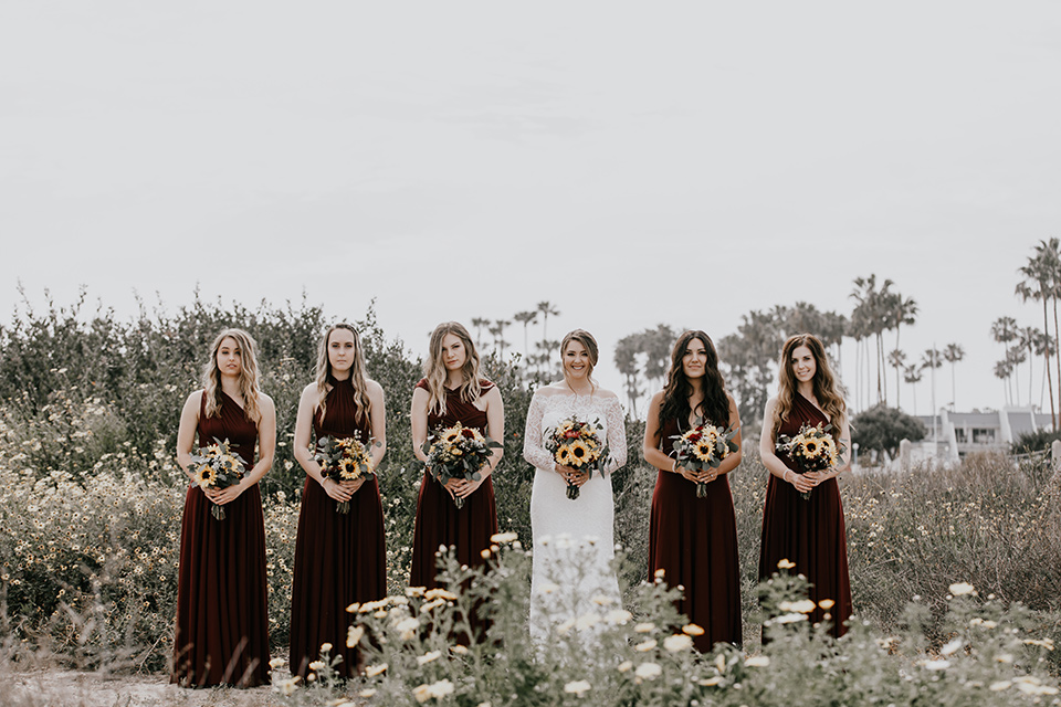 coronado-yacht-club-wedding-bride-and-bridesmaids-bridesmaids-in-red-dresses-bride-in-a-lace-form-fitting-gown