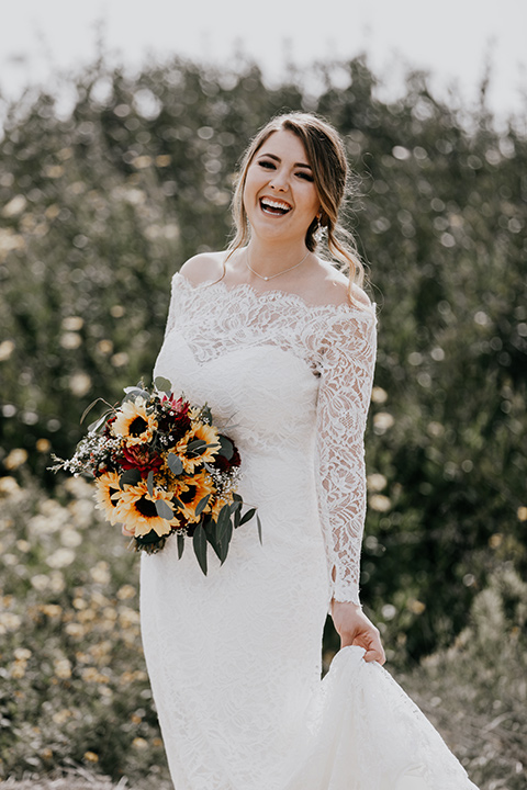 coronado-yacht-club-wedding-bride-laughing-alone-bride-in-a-lace-gown-with-sleeves-and-off-the-shoulder-detailing