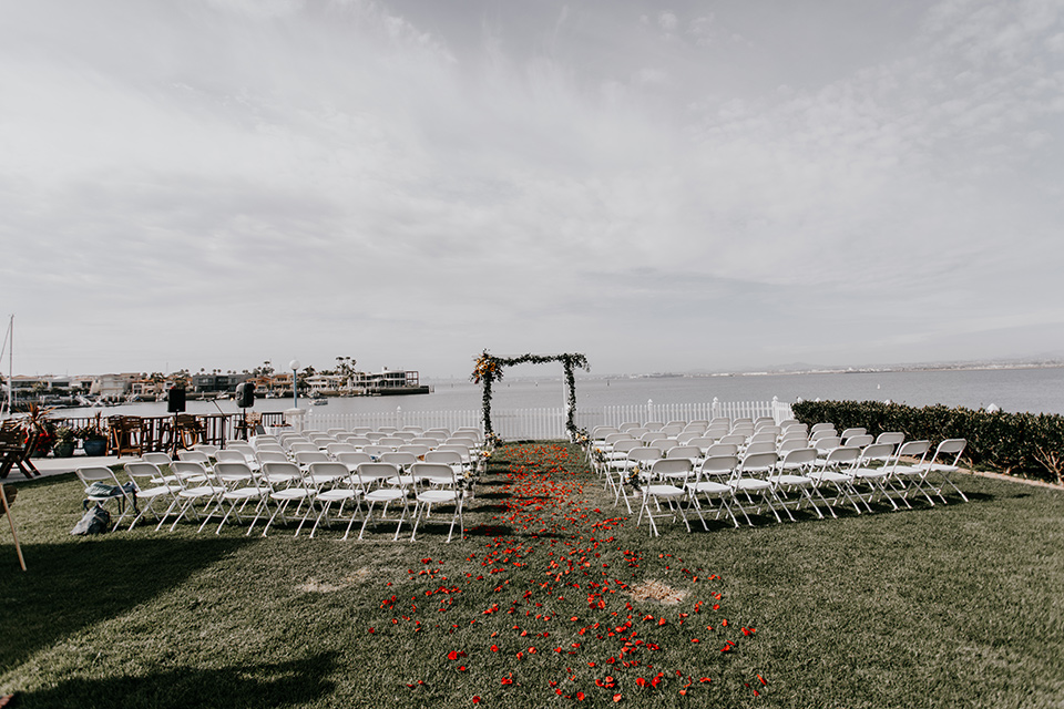 coronado-yacht-club-wedding-ceremony-space-with-white-chairs-and-wooden-archway