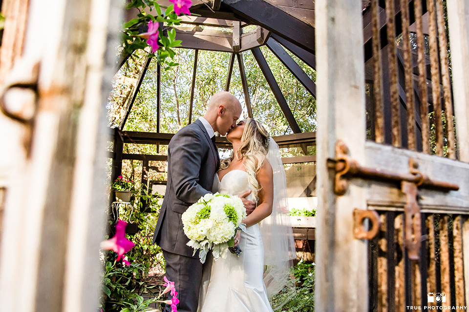 twin-oaks-weddings-bride-and-groom-in-gazebo-bride-in-a-strapless-fit-and-flare-gown-with-a-sweetheart-neckline-groom-in-a-charcoal-grey-suit-with-black-long-tie