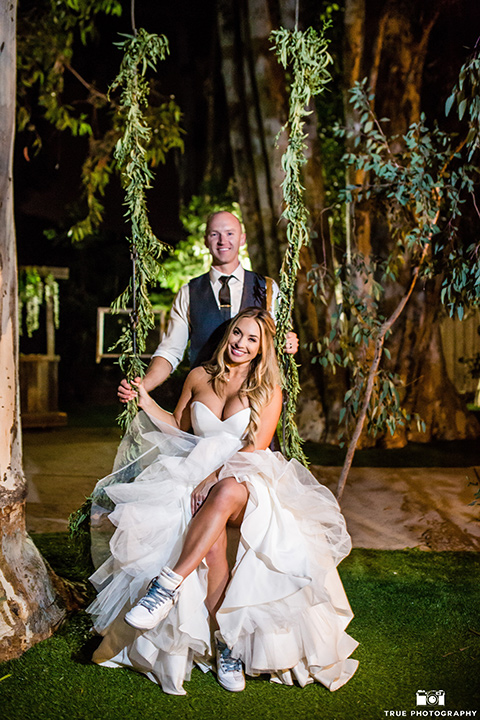 twin-oaks-weddings-bride-and-groom-on-swing-bride-in-a-strapless-fit-and-flare-gown-with-a-sweetheart-neckline-groom-in-a-charcoal-grey-suit-with-a-black-long