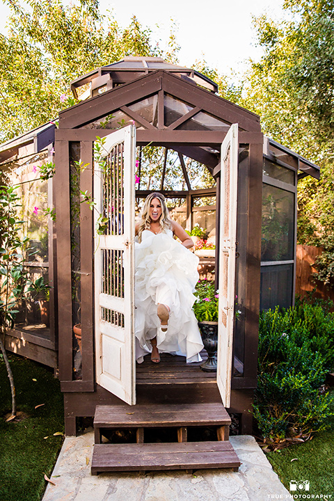 twin-oaks-weddings-bride-kicking-through-door-in-a-strapless-gown-with-a-sweetheart-neckline