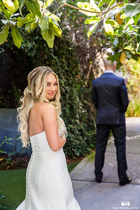 twin-oaks-weddings-first-look-bride-and-groom-hug-bride-and-groom-on-swing-bride-in-a-strapless-fit-and-flare-gown-with-a-sweetheart-neckline-groom-in-a-charcoal-grey-suit-with-a-black-long