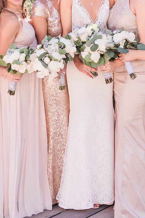 tanque-verde-ranch-arizona-wedding-close-up-on-bridesmaids-the-bride-in-a-white-formfitting-gown-with-thin-straps-the-bridesmaids-in-blush-toned-gowns