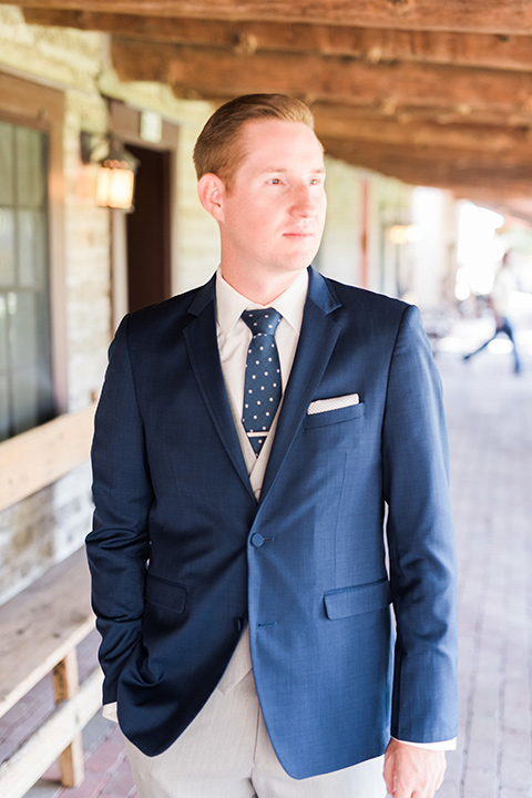 tanque-verde-ranch-arizona-wedding-groom-looking-to-the-side-in-grey-suit-pants-and-a-navy-blue-suit-coat