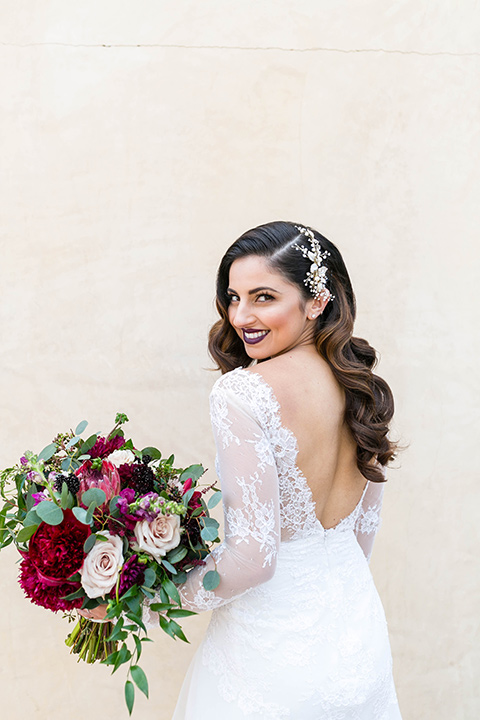 bride in a white lace gown with a full skirt and long lace sleeves and her hair in a finger wave