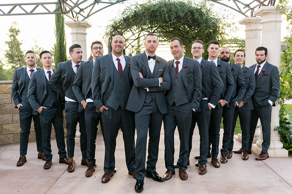  groom in a charcoal tuxedo with a black bow tie and the groomsmen in charcoal tuxedo 