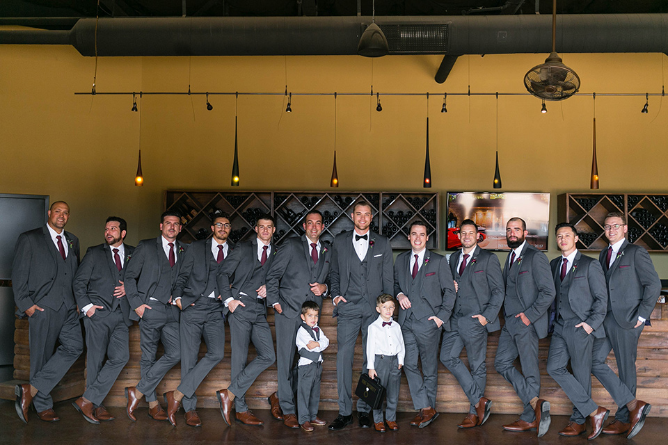  groom in a charcoal tuxedo with a black bow tie and the groomsmen in charcoal tuxedo 