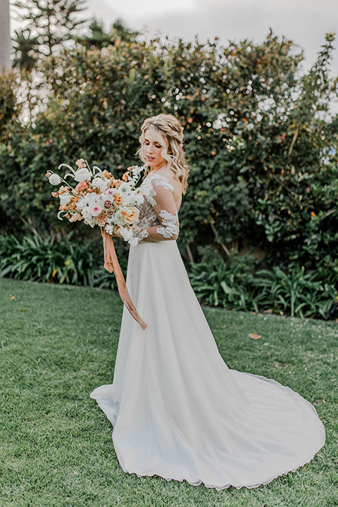 bride in a white gown with an illusion neckline hair in a loose curl