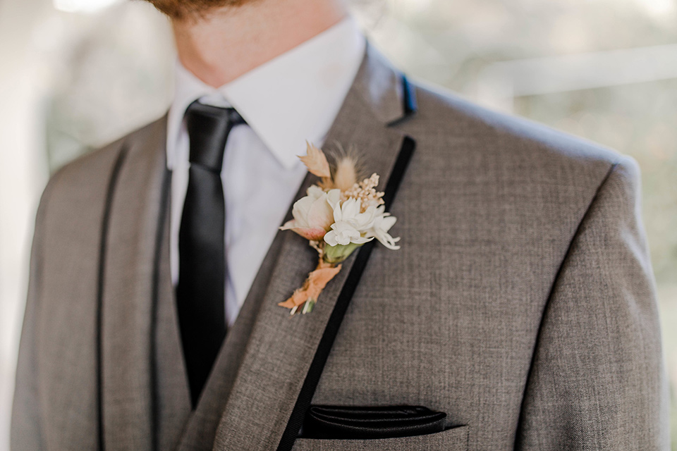 groom in a grey suit with black trim and black long tie