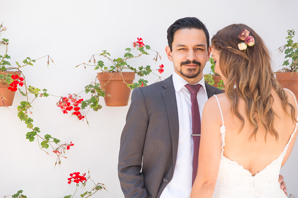 bride in a white lace with straps and the groom in a grey suit with a red long tie