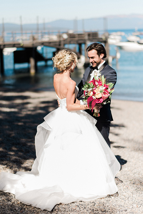 Bride and groom embrace in a photo on the lake