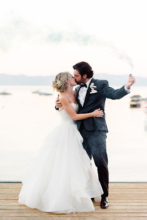 Lake Tahoe wedding bride and groom taking a selfie bride is in a strapless ballgown with a tulle skirt and the groom in a navy shawl lapel tuxedo with a black bow tie-bow-tie