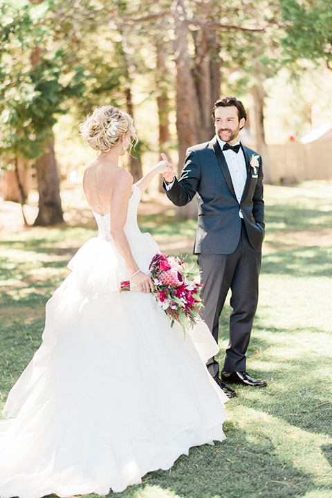 Bride and groom hold hands with tree in the background