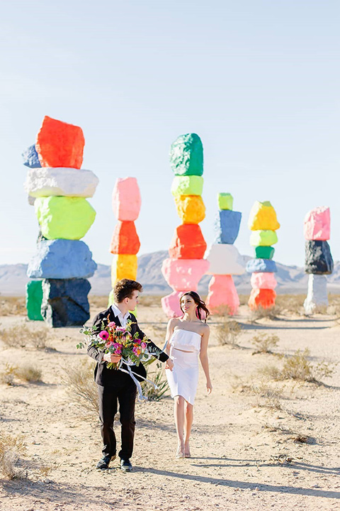 wedding bride and groom hold hand at the seven magical mountains