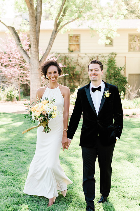 malibu-lodge-spring-wedding-shoot-bride-and-groom-walking-bride-in-a-form-fitting-gown-with-a-high-neckline