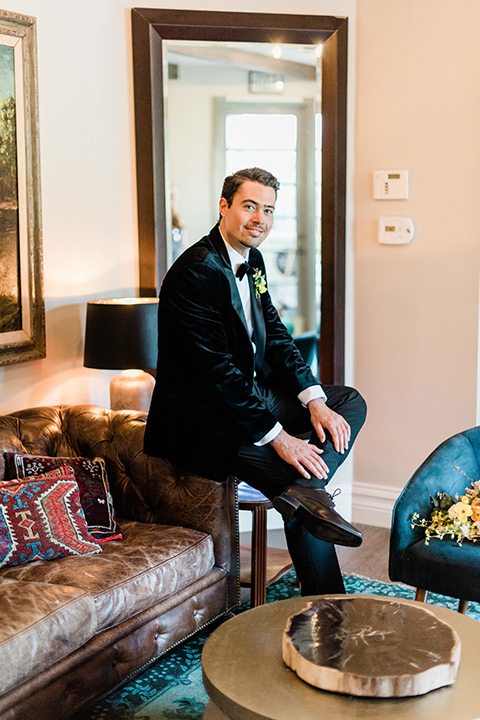 malibu-lodge-spring-wedding-shoot-groom-sitting-in-a-black-velvet-tuxedo