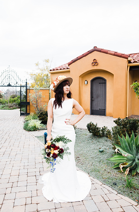 Autumn Shoot bride standing bride in a bohemian style dress with a high neckline and lace with a hat