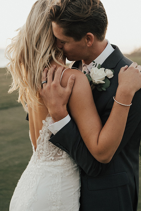 monarch-beach-resort-close-up-on-bride-and-groom-bride-in-a-lace-dress-with-thin-straps-groom-in-a-grey-suit-with-ivory-long-tie