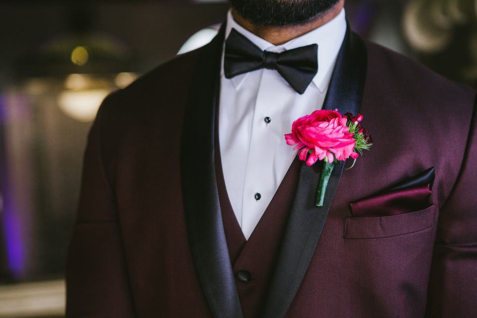 majestic-downtown-los-angeles-shoot-groom-attire-close-up-in-a-burgundy-tuxedo-with-a-satin-lapel-and-black-bow-tie