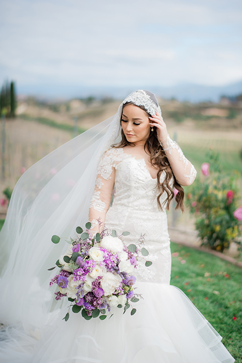  bride in a white lace gown with long sleeves and a tulle skirt