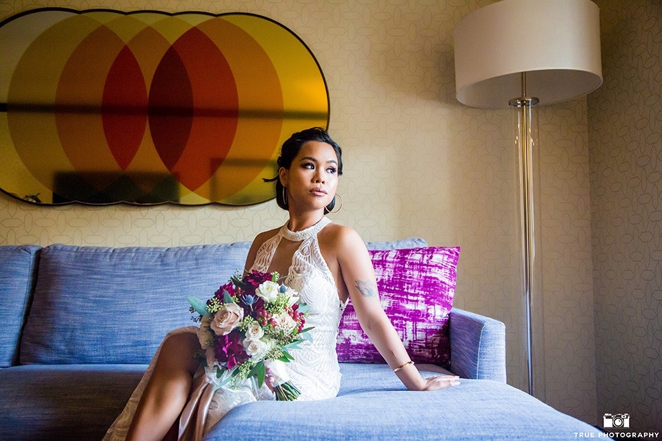 skybox-real-wedding-bride-alone-on-bed-bride-wearing-a-fitting-lace-dress-with=straps-groom-wearing-a-blue-suit-bridesmaids-in-burgundy-groomsmen-in-blue