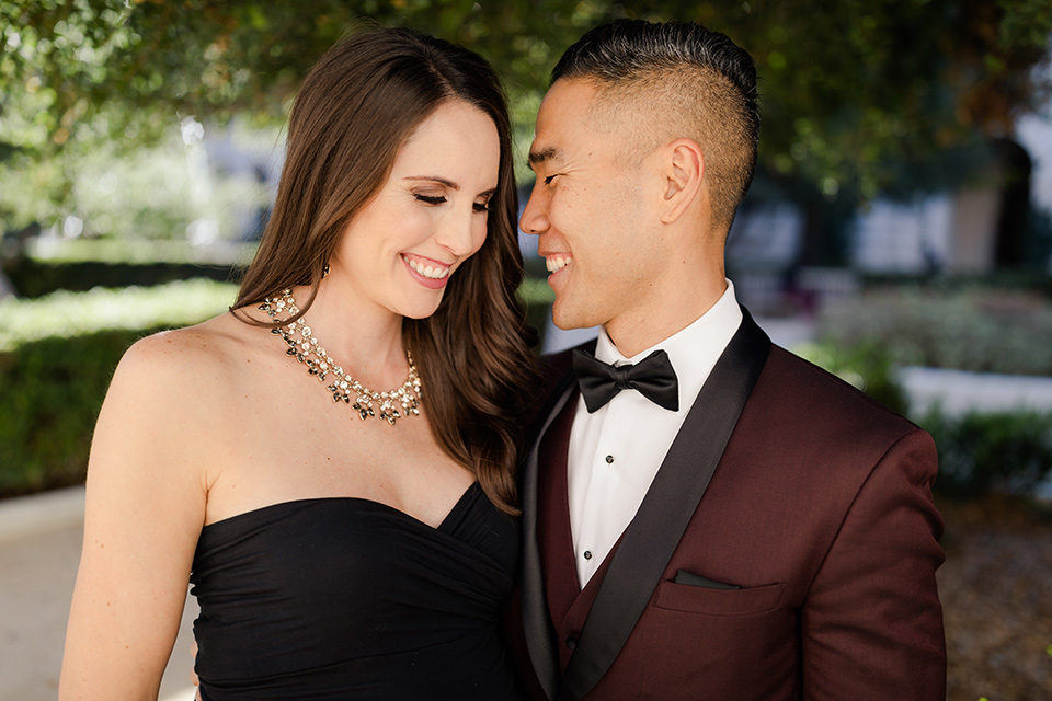 Maternity-workshop-close-up-on-mom-and-dad-mom-wearing-a-chic-black-formfittng-gown-dad-wearing-a-burgundy-tuxedo-and-black-bow-tie