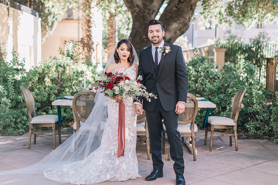 Maxwell-House-Shoot-bride-and-groom-smiling-at-camera-bride-in-a-trendy-gown-with-an-illusion-bodice-and-strapless-neckline-groom-in-a-black-suit-with-a-long-black-tie