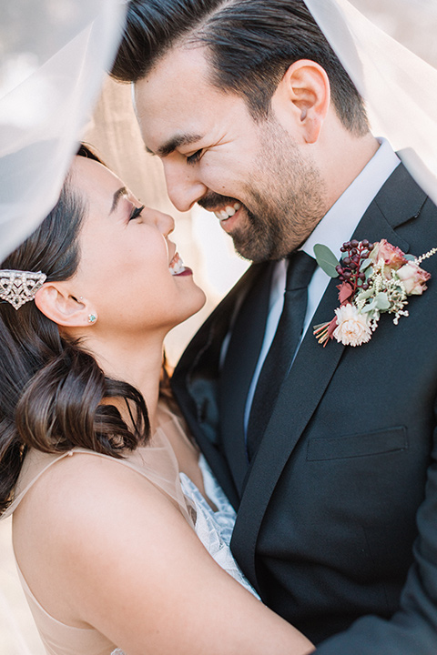 Maxwell-House-Shoot-bride-and-groom-under-veil-bride-in-a-strapless-gown-with-an-illusion-bodice-groom-in-a-black-suit-with-a-black-long-tie