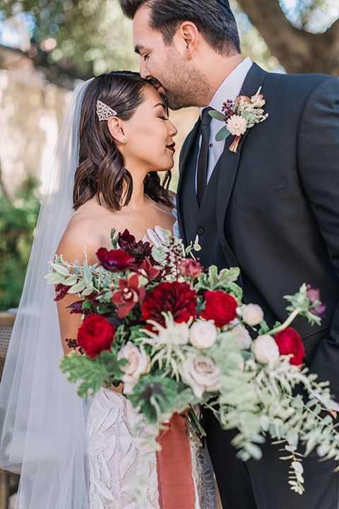 Maxwell-House-Shoot-groom-kissing-brides-head-bride-in-a-strapless-gown-with-an-illusion-bodice-groom-in-a-black-suit-with-long-black-tie