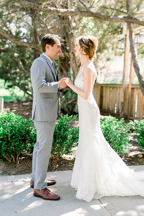 Temecula-Creek-Inn-Wedding-bride-and-groom-looking-at-each-other-bride-in-a-lace-dress-with-an-illusion-back-groom-in-a-light-grey-suit-with-blue-patterned-tie