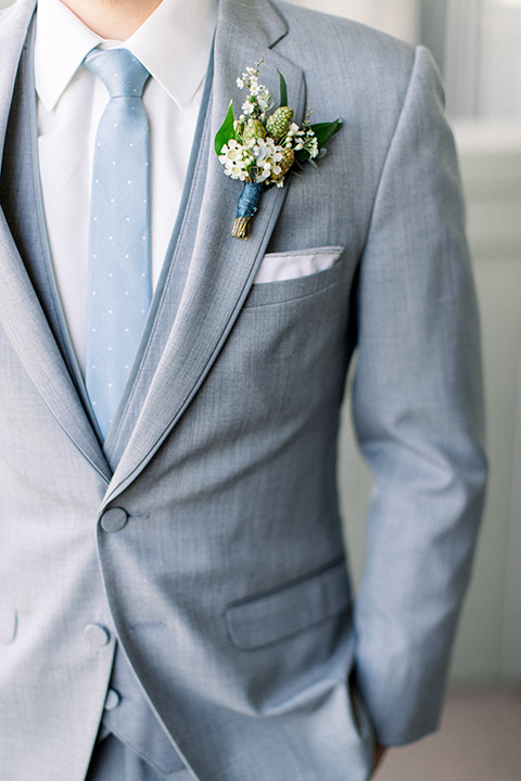 Temecula-Creek-Inn-Wedding-close-up-on-groom-attire-in-a-light-grey-suit-with-light-blue-polka-dot-tie