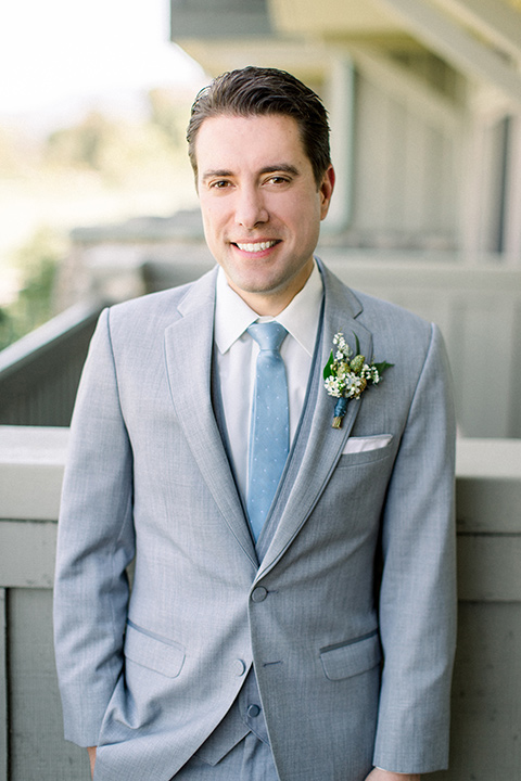 Temecula-Creek-Inn-Wedding-groom-smiling-at-camera-in-a-light-grey-suits-with-light-blue-ties