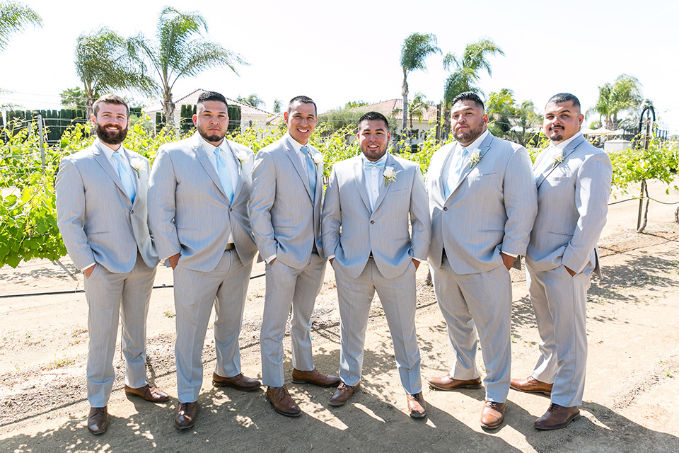  groom and groomsmen in a light grey suit and bow tie and light blue long ties