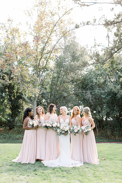 Bridesmaids and bride in pink dresses posing for a picture