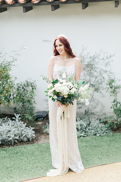  bride in a cream form fitting lace gown with a macramé headpiece 