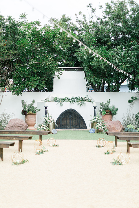  white ceremony space with string lights and long picnic seats