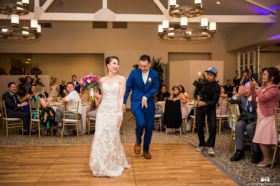 bride in a white lace strapless gown and groom in a blue suits