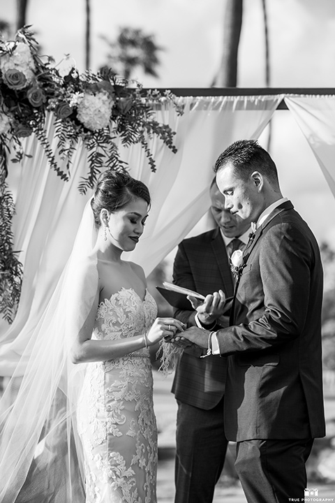  bride in a white gown with a lace strapless neckline and the groom in a blue suit 